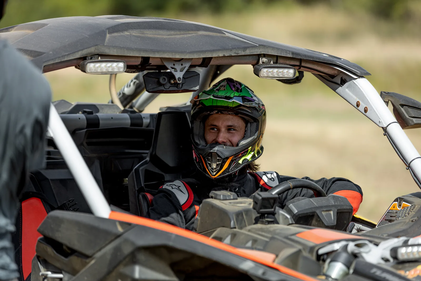 Jezdec v helmě, úsměv v kokpitu buggy